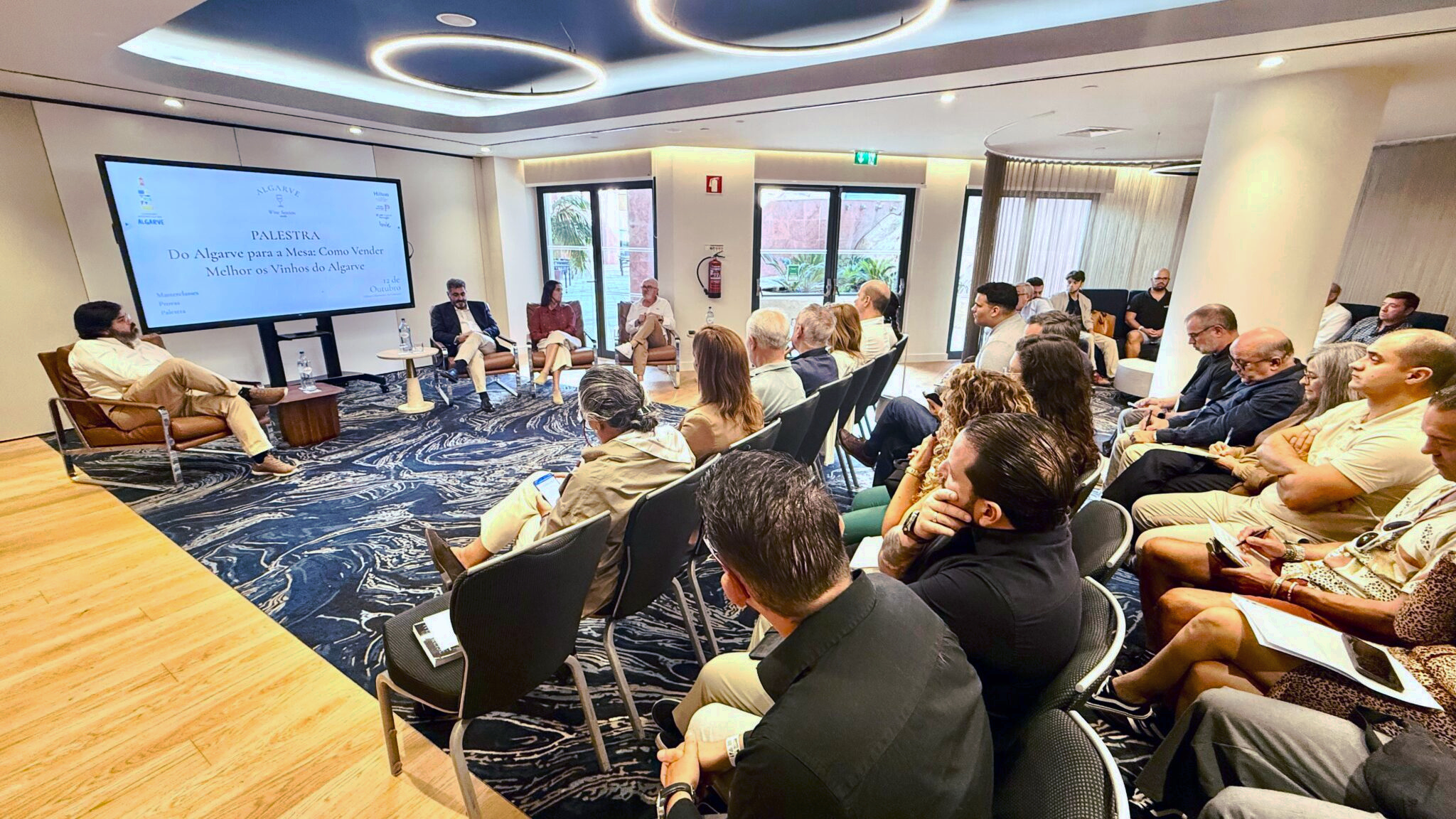 Seitlicher Blick auf Gesprächsrunde und Publikum im Hilton Vilamoura