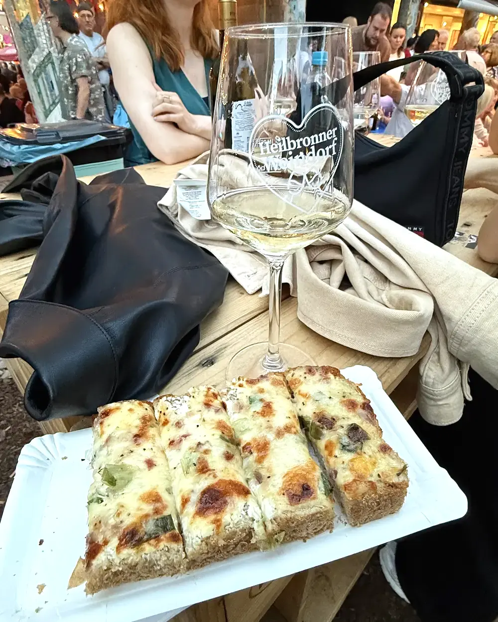 Weinglas und Flammkuchen beim Heilbronner Weindorf